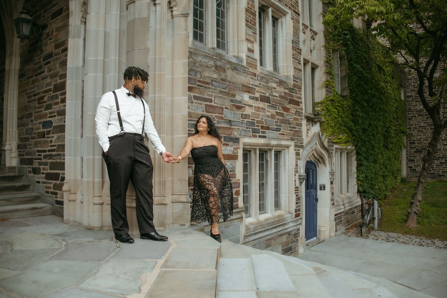 Couple holding hands among Gothic stone buildings at Princeton University, NJ