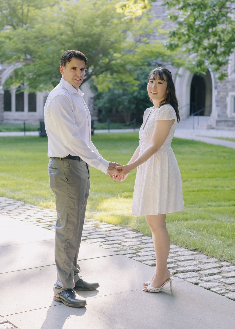 Couple holding hands on the lawn in Holder Courtyard, Princeton University