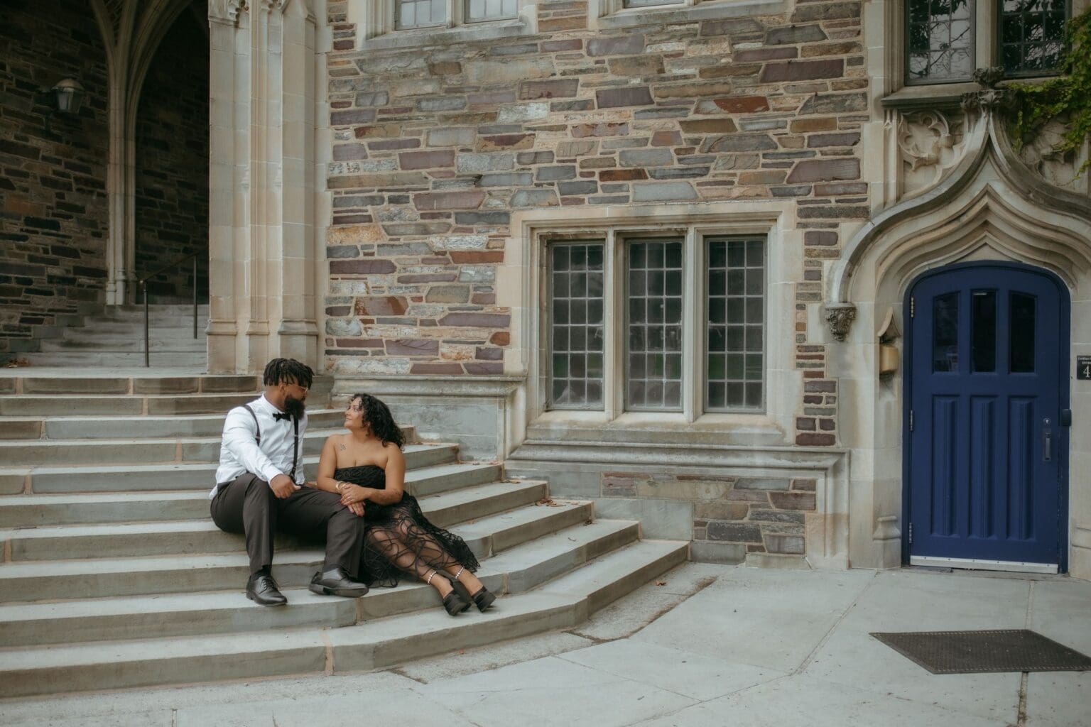 Couple sitting on the stone steps at Holder Courtyard, Princeton University