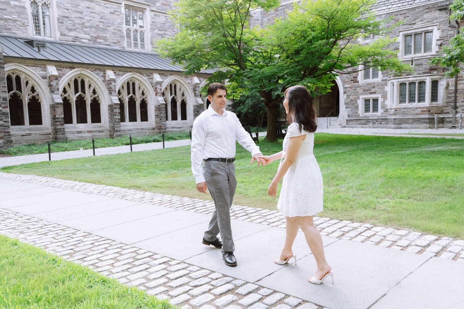 Couple walking hand in hand across a Princeton University courtyard