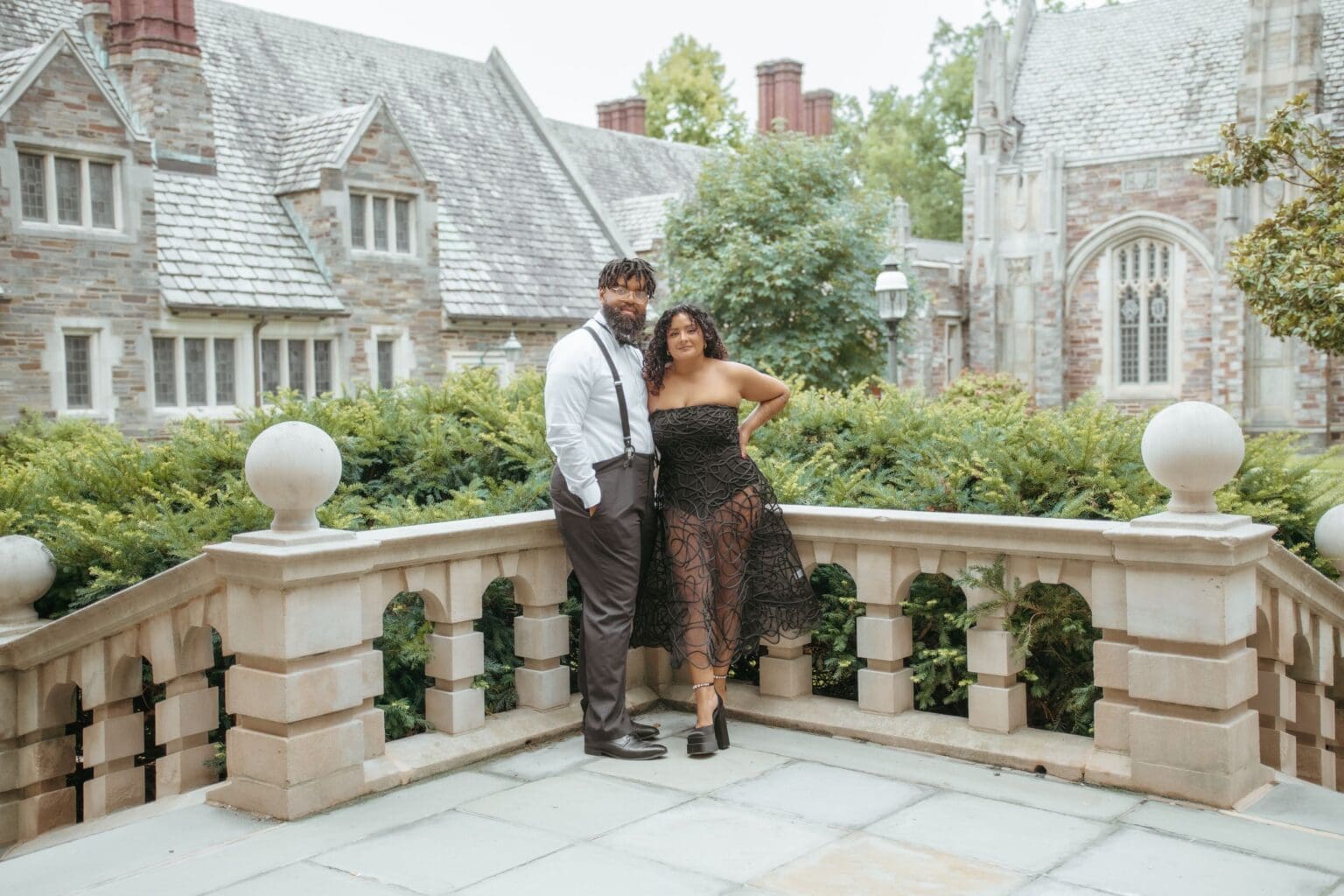 Couple posing at the stone courtyard balustrade at Princeton University